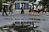 Tourists walk across rain-soaked ground with parasols at Imjingak in Paju, Gyeonggi on July 1. [YONHAP]