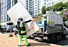 A sanitation worker in Dobong District, northern Seoul, wears a wearable robot while loading a mattress into a vehicle during a demonstration event for the device held at the district office plaza on May 14. [DOBONG DISTRICT OFFICE]