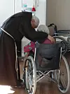 Father Uribe speaking with a patient at Sungsimwon in 2018. [SUNGSIMWON]
