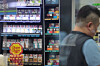A convenience store worker is seen in front of a display of cigarettes and vapes at a store in Seoul on June 12. [YONHAP]