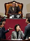 Lawmakers shout at each other as Rep. Na Kyung-won of the People Power Party continues her filibuster against a franchise business bill at the National Assembly in western Seoul on Dec. 9. [YONHAP]