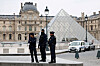 Police officers stand near the pyramid of the Louvre museum after reports of a robbery, in Paris, France, on Oct. 19. [REUTERS/YONHAP]