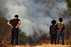 Residents in Sicheon-myeon, Sancheong County, South Gyeongsang watch the wildfire that has been sweeping the county overtake a house on March 23. [YONHAP]