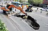 Excavator fills up a sinkhole that appeared in Yeonhui-dong in Seodaemun District, western Seoul, last Thursday. [JOONGANG ILBO]