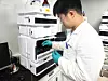 Ying Wei Wang inspects samples at a lab. [HUONS]