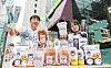 People hold up snack items released in collaboration between convenience store CU and the Doosan Bears.[CU]