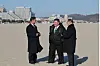 North Korean leader Kim Jong-un, center, walks down a beach in the Kalma coastal tourist area in the country's east coastal city of Wonsan, in this photo published by the Korean Central News Agency on Dec. 31. [YONHAP]