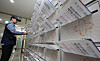 A postal worker places a booklet-style pamphlet for the presidential election into a mailbox at an apartment in Gangnam District, southern Seoul on May 19. [YONHAP]