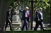 U.S. President Donald Trump, center, walks along the fence line at the North Lawn of the White House in Washington on April 23. [AP/YONHAP]