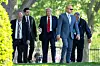 U.S. President Donald Trump, center, walks across the North Lawn of the White House in Washington on April 23 in Washington. [AP/YONHAP]