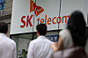 Pedestrians walk past an SK Telecom store in Seoul on Aug. 28. [NEWS1]