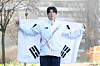 Korean figure skater Cha Jun-hwan holds up the national flag during an interview with the JoongAng Ilbo at the Olympic Village in Milan on Feb. 15. [KIM JONG-HO]