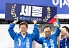 President Lee Jae-myung, left, then the Democratic Party presidential candidate, holds a placard calling to 'complete' Sejong's creation as an administrative capital with former Rep. Lee Hae-chan during his campaign in the city last month. [NEWS1]