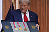 U.S. President Donald Trump looks at a full set of medals from the 1984 Olympics in Los Angeles, presented to him by Casey Wasserman, chair of LA28, during an event regarding the 2028 Los Angeles Olympic Games, in the South Court Auditorium of the Eisenhower Executive Office Building on the White House campus, Aug. 5, in Washington. [AP/YONHAP]