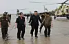 North Korea’s leader Kim Jong-un, center, visits flooded areas in Sinuiju and Uiju County in North Pyongan Province Sunday to guide an operation to rescue thousands of residents isolated in the areas in a photo carried by its official Korean Central News Agency on Monday. [YONHAP]