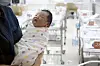 A newborn is held by a nurse at a hospital in Gangseo District, western Seoul, on Feb. 26. [JUN MIN-KYU]