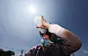 A farmer drinks water while working under the sun in Goryeong County in South Gyeongsang on July 2. [YONHAP]