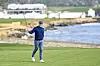 Rory McIlroy raises his putter to fans as he celebrates his two stroke victory on the 18th hole green during the final round of the AT&T Pebble Beach Pro-Am at Pebble Beach Golf Links on Feb. 2, in Pebble Beach, California. [GETTY IMAGES]