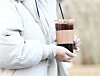 A pedestrian carries a cup of iced americano on a cold December day in Seoul in 2022 [NEWS1]