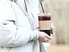 A pedestrian carries a cup of iced americano on a cold December day in Seoul in 2022 [NEWS1]