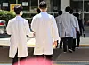 Doctors walk near a hospital in Seoul on Friday. [NEWS1]