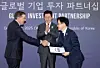 President Lee Jae Myung, center, claps as Amazon Web Services CEO Matt Garman, left, hands an investment filing to Industry Minister Kim Jung-kwan during the Asia-Pacific Economic Cooperation gathering in Gyeongju, North Gyeongsang, on Oct. 29, 2025. [YONHAP]