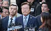 Democratic party leader Lee Jae-myung, center, answers reporters' questions outside the Seoul Central District Court in southern Seoul on Nov. 15, after the court sentenced him to a suspended one-year prison term for lying during the 2022 presidential election campaign. [YONHAP]