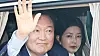 Ousted President Yoon Suk Yeol, left, waves his hand as he departs from his presidential residence in Yongsan District in central Seoul on April 11. His wife Kim Keon Hee is seen behind him in the car. [NEWS1]