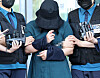 The 23 year-old Jung Yoo-jung, who killed another woman of same age in Busan being taken by police on June 2. Although Jung's identity was disclosed, she continued to hide her face in public.