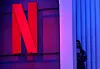 A woman stands next to a logo of Netflix during an event in Mumbai, India, Feb. 29, 2024. [REUTERS/YONHAP]