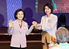 Kim Hye-kyung, the spouse of Democratic Party presidential candidate Lee Jae-myung, right, and Seol Nan-young, the spouse of People Power Party candidate Kim Moon-soo, hold hands during the 70th anniversary ceremony of the Jogye Order’s central laity association at the Shilla Hotel in Jung District, central Seoul, on May 12. [YONHAP]