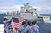 Crewmembers of the Japanese Maritime Self-Defense Force's JS Shimakaze guided missile destroyer hold a U.S. flag toward the U.S. Navy's USNS Harvey Milk oiler during an exercise in the Virginia Capes’ operating area in the Atlantic Ocean on Sept. 24, 2024, in this photo provided by the U.S. Navy. [REUTERS/YONHAP]