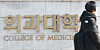 A pedestrian walks by a medical college in Seoul on March 6. [YONHAP]