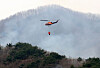 A helicopter equipped for firefighting flies over a wildfire in Hadong, South Gyeongsang on March 28. [NEWS1]