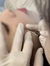 Tattooist Park Ja-young places a semi-permanent beauty mark on a client’s face — a rising trend among young Koreans seeking aesthetic or “lucky” mole placements. [COURTESY OF PARK JA-YOUNG]