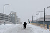 A person walks with a scooter on a bridge over train tracks behind Union Station, as a major winter storm spreads across a large swath of the United States, in Washington, Jan. 25. [REUTERS/YONHAP]