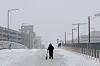 A person walks with a scooter on a bridge over train tracks behind Union Station, as a major winter storm spreads across a large swath of the United States, in Washington, Jan. 25. [REUTERS/YONHAP]