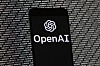 The OpenAI logo appears on a mobile phone in front of a computer screen with random binary data, on March 9, 2023, in Boston. [AP/YONHAP]