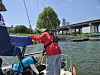 Mary grips onto the boom as Hyun checks the fuel tank. [SAILING PARADISE]
