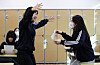 Students at Sajik Girls' High School in Dongnae District, Busan, hug each other after receiving their College Scholastic Ability Test report cards on Friday.