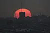 The sun sets over damaged buildings in the Gaza Strip, seen from southern Israel, on July 1. [AP/YONHAP]