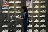 A woman tries out a shoe at an Adidas sportswear store inside a shopping mall in Beijing on April 12. [AP/YONHAP]