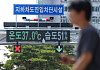 An electric board over a road in downtown Seoul shows the tempertaure on July 8. [YONHAP]