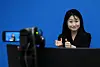 A sign language interpreter relays spokesperson Kang Yu-jung’s press briefing announcing President Lee Jae Myung's visit to the United States for a summit with U.S. President Donald Trump at the Yongsan presidential office in central Seoul on Aug. 12. The presidential office launched simultaneous sign language interpretation service for the first time the previous day. [JOINT PRESS CORPS]
