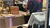 A bakery employee packages two Dubai chewy cookies from a tray kept behind a counter. [WOO JI-WON]