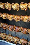 Rows of whole chickens glistening as they slowly spin over electric heat [JOONGANGILBO]