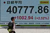 A man walks in front a stock quotation board showing the Nikkei share average outside a brokerage in Tokyo on July 23. [REUTERS/YONHAP]
