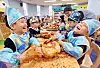 Children smile while making Kimchi at their day care center in Gwangju last December. [YONHAP]