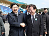 People Power Party floor leader Kweon Seong-dong, left, and Democratic Party leader Lee Jae-myung, right, shake hands after attending a ceremony at the Daejeon National Cemetery on March 28. [JOINT PRESS CORPS]