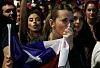 A woman kisses a Chilean flag while people rejecting the new constitution draft celebrate after knowing the first results of the referendum vote, in Santiago, on Sept. 4. A resounding majority in Chile rejected the proposed constitution that sought to change the one inherited from the Augusto Pinochet's dictatorship (1973-1989) for one with more social rights. With almost 100 percent of votes counted, the reject camp led with nearly 62 percent compared to just 38 percent for those in favor. [AFP/YONHAP]